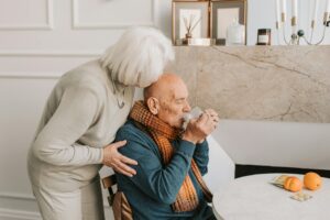 A loving elderly couple sharing a tender moment in their cozy home setting.